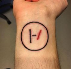 a person's wrist with a tattoo on it that has the letter f in red