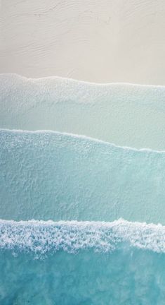 two surfers are riding the waves on their boards in the blue water at the beach