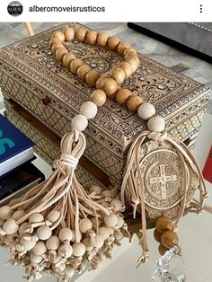 a wooden beaded necklace sitting on top of a table next to a book and other items