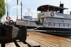 two boats are docked at the dock in front of each other on a sunny day