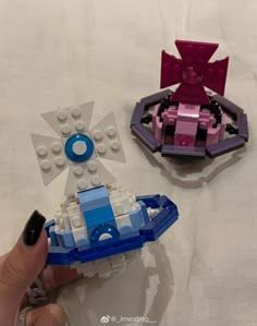 two legos that are sitting on a bed together, one has a boat and the other is a spaceship