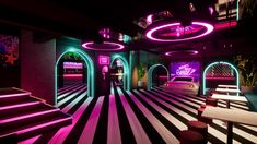 a man standing in the middle of a room filled with neon lights and striped flooring