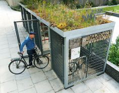 a man riding a bike next to a green roof