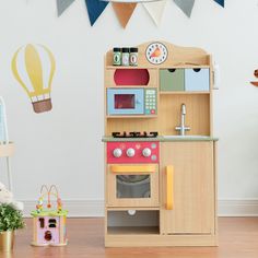 a child's wooden play kitchen with toys around it