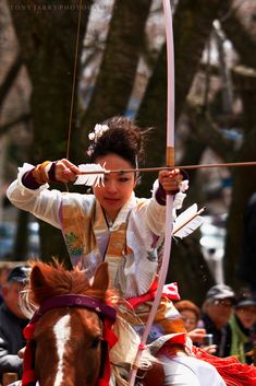 a person on a horse with a bow and arrow