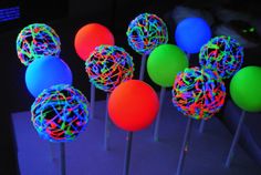 neon colored lollipops are sitting on sticks