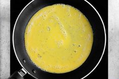 a frying pan filled with yellow liquid on top of a stove