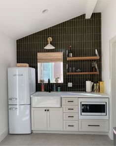 a white refrigerator freezer sitting inside of a kitchen next to a counter top oven