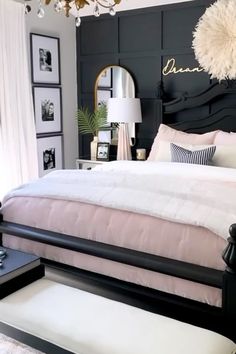 a black and white bedroom with chandelier, bed, nightstands and pictures on the wall