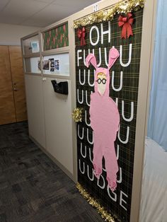 an office cubicle decorated with paper mache and gold glitters, including a pink llama