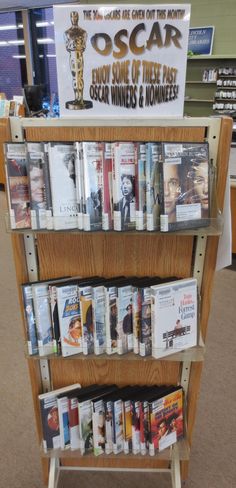 a book shelf with many books on it in a bookstore or office area that also has an oscar award sign