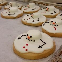 some cookies with frosting and snowmen on them are ready to be baked in the oven