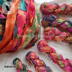 there are many different types of yarns on the table and one is pink, green, orange