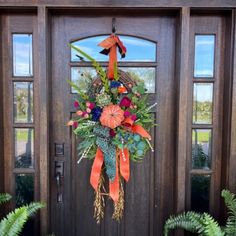 a front door decorated with flowers and greenery