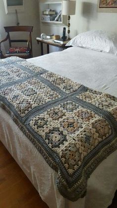 a bed with a white bedspread covered in crochet