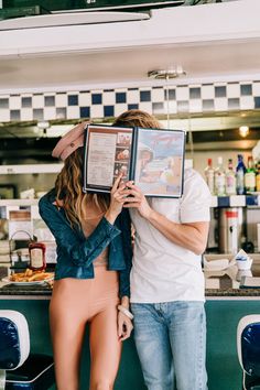 a man and woman standing next to each other in front of a counter