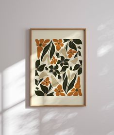 an orange and black floral print hangs on the wall in front of a white background