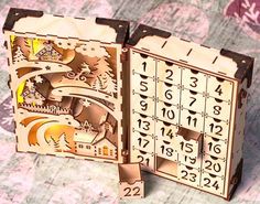 an open wooden box with numbers and pictures on the inside, sitting on a patterned surface