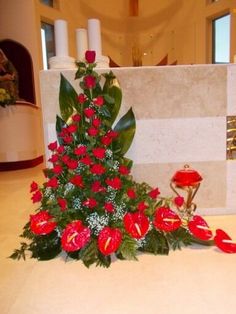 red flowers and greenery in front of a church alter