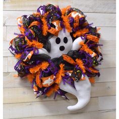 a wreath made to look like a ghost with orange, black and purple decorations on it