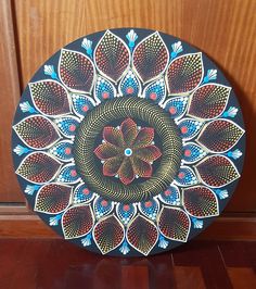 a decorative plate is sitting on the floor in front of a wooden paneled door