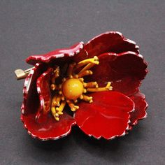 "DESCRIPTION: Step into the elegance of the 1940s with this enchanting vintage brooch, a testament to the era's distinctive charm. The brooch showcases a delightful 3D hibiscus flower painted with vibrant red enameling on its petals, while the center boasts a sunny yellow enameling, adding a pop of color to the design. With dimensions measuring 1 1/2\" by 1 1/4\", this brooch captures the essence of a bygone era's fashion. While the front exudes timeless beauty, the wear on the enamel at the back tells a story of its journey through time, making it a cherished piece with character and history. NOTE: Insurance fee and handling fee are included in the shipping fee for items worth $400 and above. SHIPPING: The shipping fee includes postage, packaging, and handling. We typically ship items wit Fashion Eras, Handcrafted Bracelets, Sunny Yellow, Hibiscus Flower, Flower Pins, Vintage Brooch, Hibiscus Flowers, Flower Brooch, Vintage Pieces