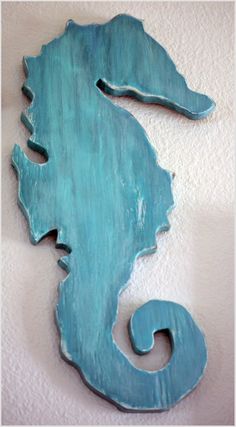 a blue seahorse is hanging on the wall