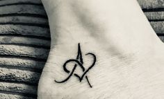 a small tattoo on the foot of a woman's foot with an x and heart