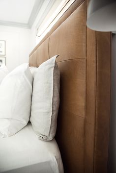 a bed with two white pillows on top of it and a lamp next to it