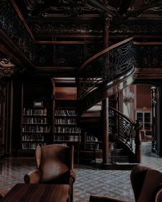 a room with two chairs and a spiral staircase in the center is full of books