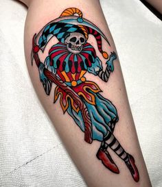 a person with a colorful tattoo on their arm holding a knife and wearing a skull headdress