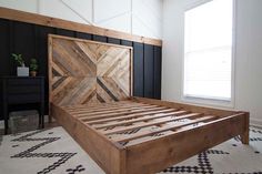 a bed with wooden headboard and foot board on carpeted flooring in front of window