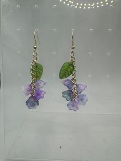 two pairs of earrings with green leaves and purple flowers