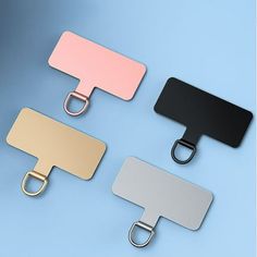 three different colored metal clip holders on a blue and white background, one is black, the other is pink