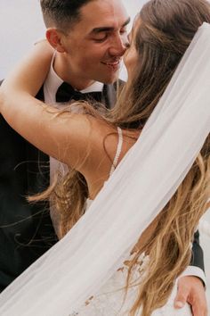 a bride and groom kissing under the veil