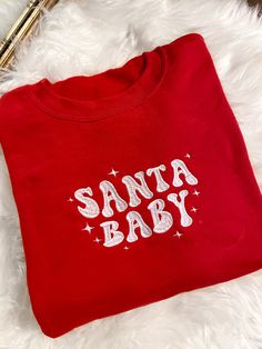 Get festive with our Santa Baby Crewneck Sweatshirt! The Unisex Sizing makes the sweatshirt run slightly larger than your average sweatshirt for women. Most men find their normal size to be more snug. If you want a slightly looser fit, size up one size. Please check out our size chart for measurements to ensure an accurate fit. PLEASE BE SURE TO INPUT YOUR CORRECT SIZE/COLOR + SHIPPING ADDRESS. We will not be responsible if it is incorrect! Refunds/Exchanges accepted, please read our Refund Poli Retro Christmas Sweatshirt, Christmas Crewneck Sweatshirt Cricut, Winter Sweatshirt Ideas, Cute Christmas Sweatshirts, Christmas Embroidery Sweatshirts, Embroidered Clothes Ideas, Vinyl Sweatshirt Ideas, Sweatshirt And Shirt Outfit, Valentines Clothes