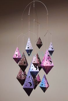 a wind chime hanging from the ceiling with purple and blue paper decorations on it