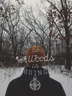 a person standing in the snow wearing a brown hat with words going to the woods