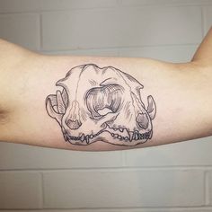 a man's arm with a black and white tattoo of a skull on it