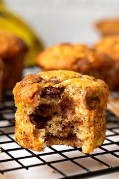 banana chocolate chip muffins on a cooling rack with bananas in the background and text overlay