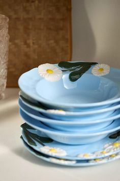 a stack of blue plates with daisies on them