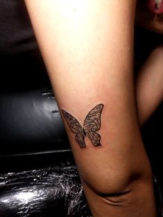 a woman's leg with a small butterfly tattoo on the left side of her calf