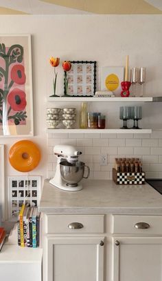 a kitchen with white cabinets and an orange mixer