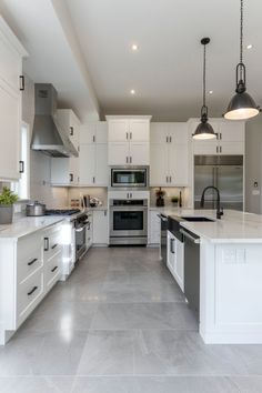 a large kitchen with white cabinets and stainless steel appliances in it's center island