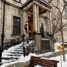 an old building with snow on the ground and stairs leading up to it's entrance