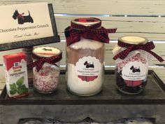 three jars filled with different types of food on top of a table next to boxes