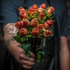 a man holding a bouquet of roses in his hand