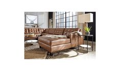 a brown leather couch sitting on top of a rug