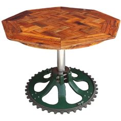 a wooden table sitting on top of a green metal sprinkled gear wheel in front of a white background