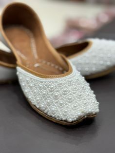 These pearl embroidered khussa's are neatly handcrafted from India ! They are super comfortable to wear with ultra-soft leather, and double cushioned sole. They are perfect for any occasion!  These pairs are hand-embroidered with pearls These shoes feature:  * pearl work * perfect for any occasion * Comfortable to wear * Double Cushioned sole   100 % Recyclable  PLEASE NOTE that these shoes are sized on standard US sizing. However, they have a snug and tight fit (as all brand new shoes usually a Festive Closed Toe Ballet Flats, Slip-on Flats With Mirror Work For Wedding, Wedding Ballet Flats With Closed Toe, Elegant Embroidered Closed Toe Flats, Embroidered Flat Heel Wedding Shoes, Festive Handwork Round Toe Flats, Elegant Handwork Flats, Elegant Handwork Flats For Festive Occasions, Elegant Mirror Work Flats For Festive Occasions